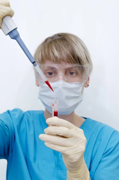 Laboratuvar asistanı kan örneğini analiz ediyor.