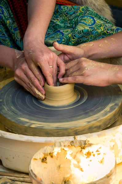 Bir öğrenci Clay potters tekerlek üzerinde çanak çömlek yapmayı öğreten bir öğretmen elinde