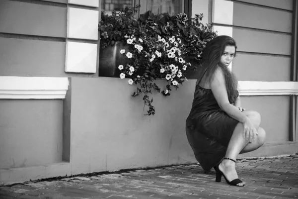 Chica en la calle entre las flores . —  Fotos de Stock