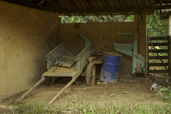 Small rural property garage in Guarani, state of Minas Gerais, Brazil, with equipment and abandoned cart
