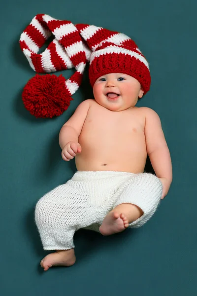 Bonito alegre natal bebê em um gnome vermelho e branco chapéu de cauda longa — Fotografia de Stock