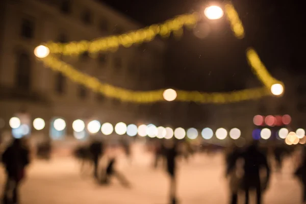 blurred picture of people ice-skating on a rink during holidays