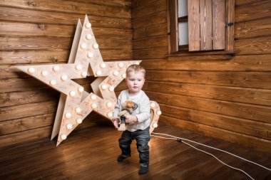 dekore edilmiş bir ahşap evin içinde duran ve tutmak bir oyuncak bir çocuk