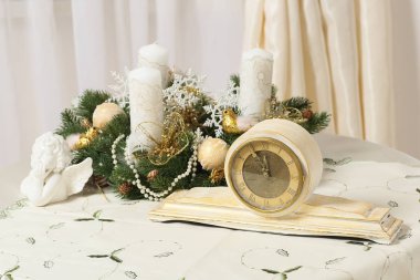 Noel çelenk bir tabloda bir antika tasarımcı saat ile dekore edilmiştir.