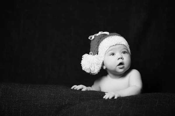 Черно-белое фото рождественского ребенка с открытым ртом в рождественской шляпе — стоковое фото