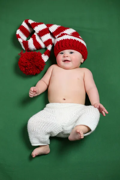 Bonito alegre natal bebê em um gnome vermelho e branco chapéu de cauda longa — Fotografia de Stock