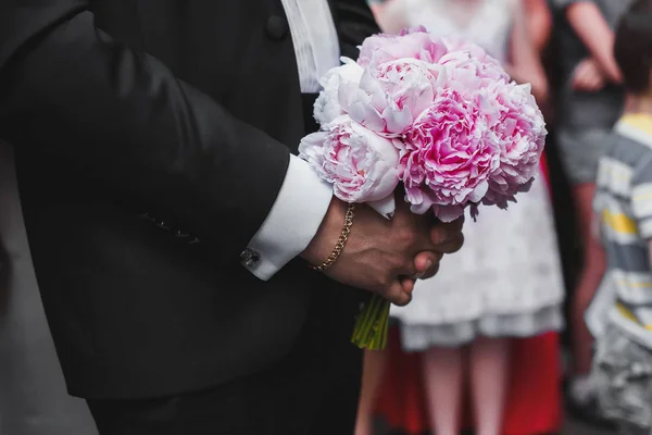 Шафер в смокинге с розовым свадебным букетом — стоковое фото