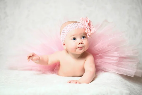Schattig klein babymeisje in een mooie roze uitlopende jurk — Stockfoto