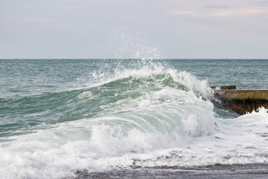 Dalgalar deniz üzerinde bulutlu pier yakınındaki