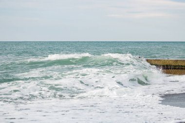 Dalgalar deniz üzerinde bulutlu pier yakınındaki