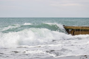 Dalgalar deniz üzerinde bulutlu pier yakınındaki