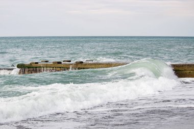 Dalgalar deniz üzerinde bulutlu pier yakınındaki