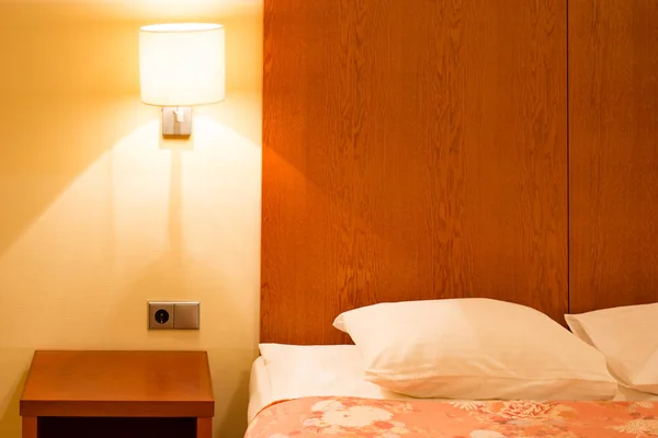 Bed with a lamp in the hotel room — Stock Photo, Image