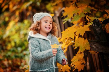 Küçük kız holding sarı yaprak 
