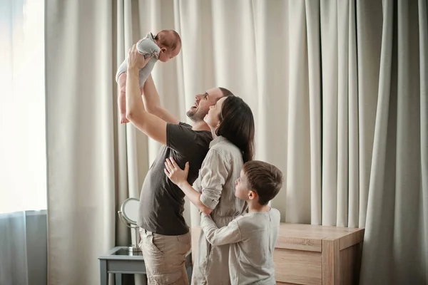 Сім'я тримає новонароджену дитину — стокове фото