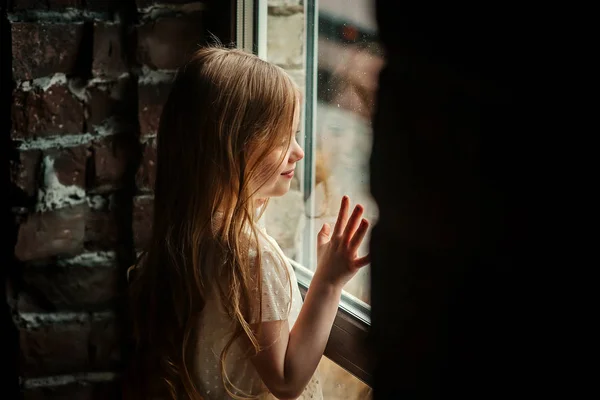 girl looking through window