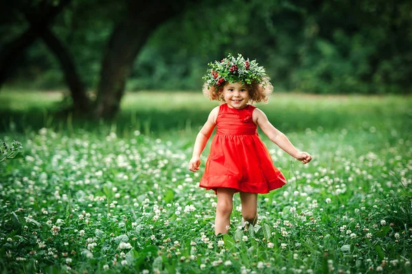 Girl in flower wreath walking outdoors — Stock Photo, Image