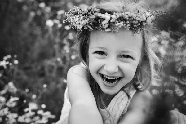 Niña en corona de flores en el campo de margaritas — Foto de Stock