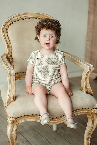 Маленькая девочка сидит на винтажном стуле — стоковое фото