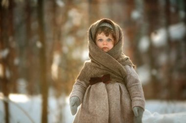 Kısa kıvırcık saçlı ayakta sıcak şal, vintage ceket ve karlı Park mittens ile sevimli küçük kız