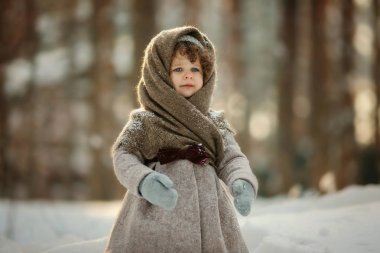 Kısa kıvırcık saçlı ayakta sıcak şal, vintage ceket ve karlı Park mittens ile sevimli küçük kız