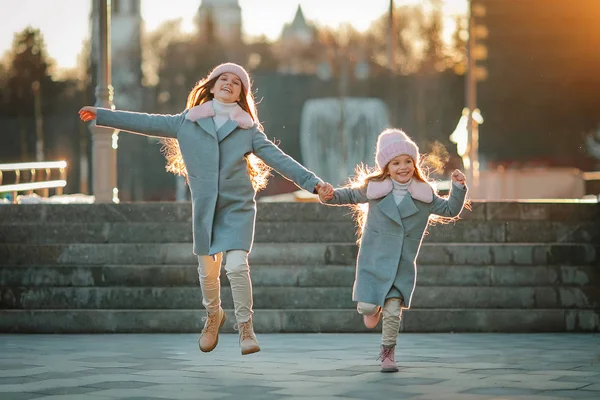 Duas Irmãs Adoráveis Pulando Mãos Dadas Rua Cidade — Fotografia de Stock