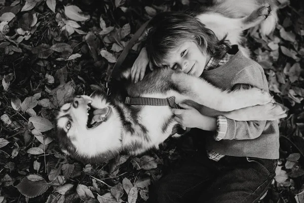 Colpo Monocromatico Bambino Con Capelli Ricci Abbracciando Siberiano Cane Husky — Foto Stock