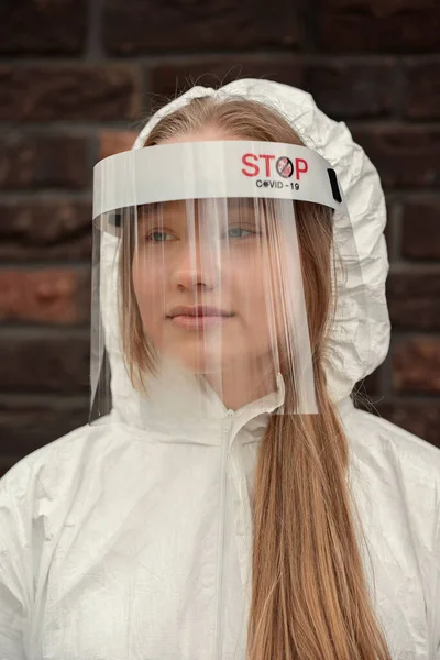 Woman wearing protection medical screen or plastic shield on her face, for corona virus or Covid-19 protection.