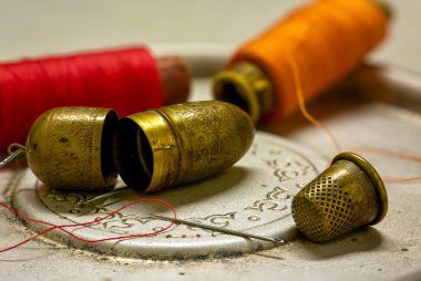 Yüksük, iğne ve iplikle dolu bir hayat. Dikiş için aksesuarlar. Eski model. Retro.