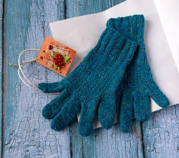 Knitted gloves lie on an old board.