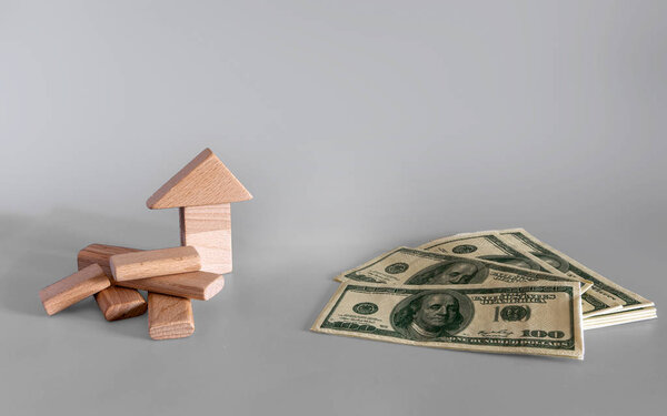 Концепция ипотечного бизнеса. Инвестиции в товары или недвижимость. На сером фоне деньги и деревянные кубики
.