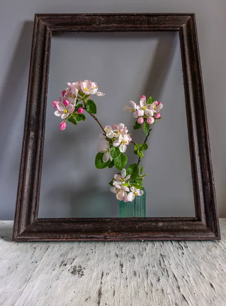 Still life with a flowering branch in the frame. Interior.