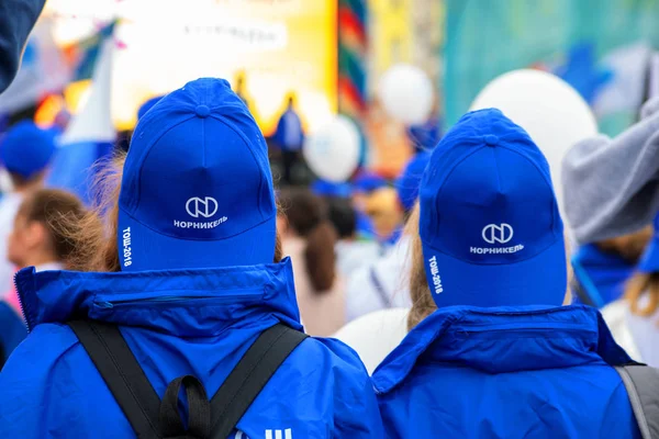 Twee studenten op een demonstratie in caps met het Norilsk Nickel logo — Stockfoto