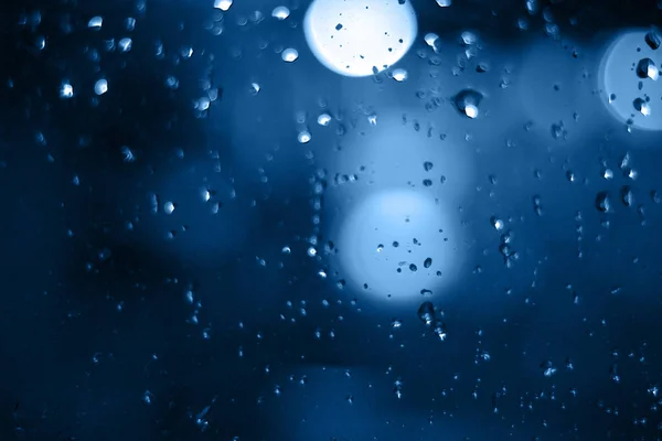 Chuva cai na janela com bokeh no fundo blure — Fotografia de Stock