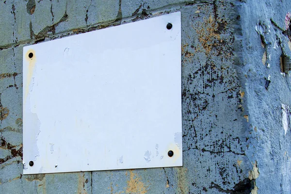 Metal plaque mounted on an old stone wall.