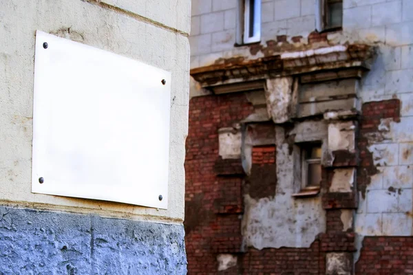 Placa vazia em uma parede de tijolo velha, restauração de um edifício velho . — Fotografia de Stock