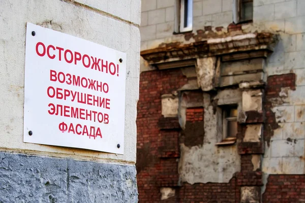 Порожня пластина на старій цегляній стіні, реставрація старої будівлі. Російський текст старанно обвалив фасад. — стокове фото