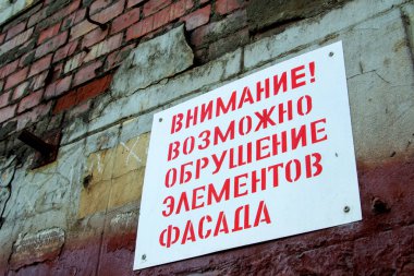 Eski bir tuğla duvardaki tabak, eski bir binanın restorasyonu. Rus metni ön cepheyi dikkatlice çökertti
