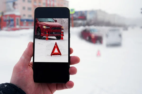 Cierre la mano sosteniendo el teléfono inteligente y tomar una foto de accidente de coche —  Fotos de Stock