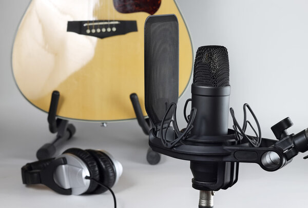 The studio microphone against the background of musical instruments