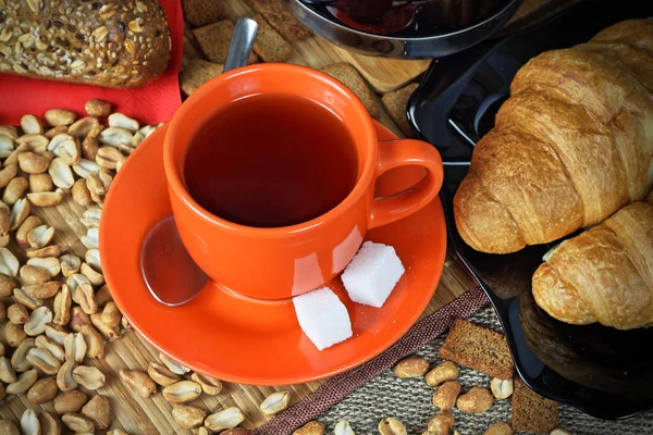 紅茶とクロワッサンのオレンジ カップ — ストック写真