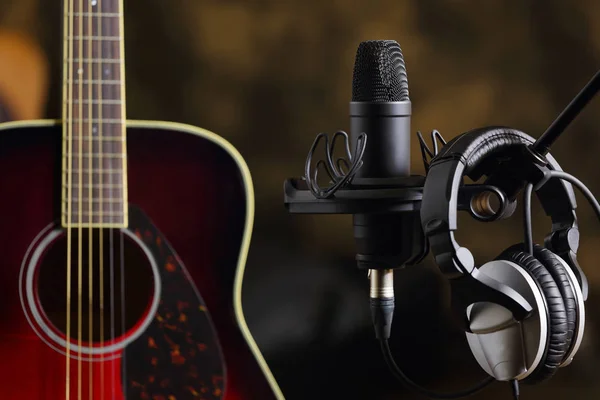 Acoustic guitar, microphone and earphones