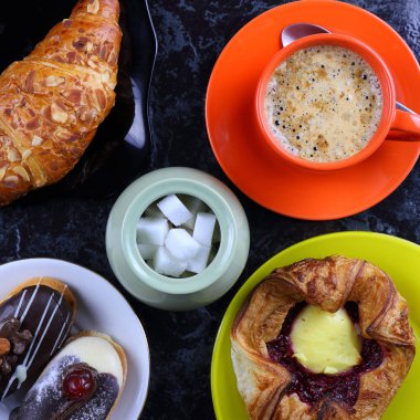 Kahve, pasta ve çörek ile turuncu kupa