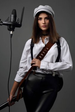 Elektro gitarlı ve mikrofonlu kız müzisyen.