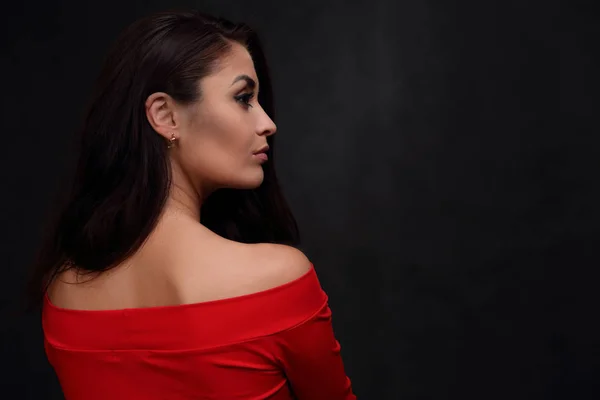 Siyah arka planda kırmızı elbiseli güzel bir kadının profili. — Stok fotoğraf