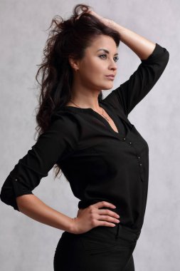 Siyah bluzlu güzel bir kadın ve açık renk bir sırt grubunda kot pantolon.