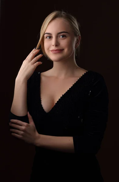 Retrato de uma menina loira sorridente em um vestido preto — Fotografia de Stock