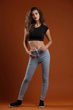 Stüdyo boy portresi. Siyah bluzlu, ince, güzel bir kız.