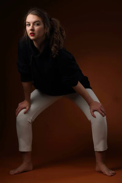 スタジオポートレートのA可愛いです十代の女の子で黒パーカーと光色のスウェットパンツ — ストック写真