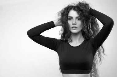 Açık arkaplanda uzun saçlı bir kız dansçının stüdyo portresi.